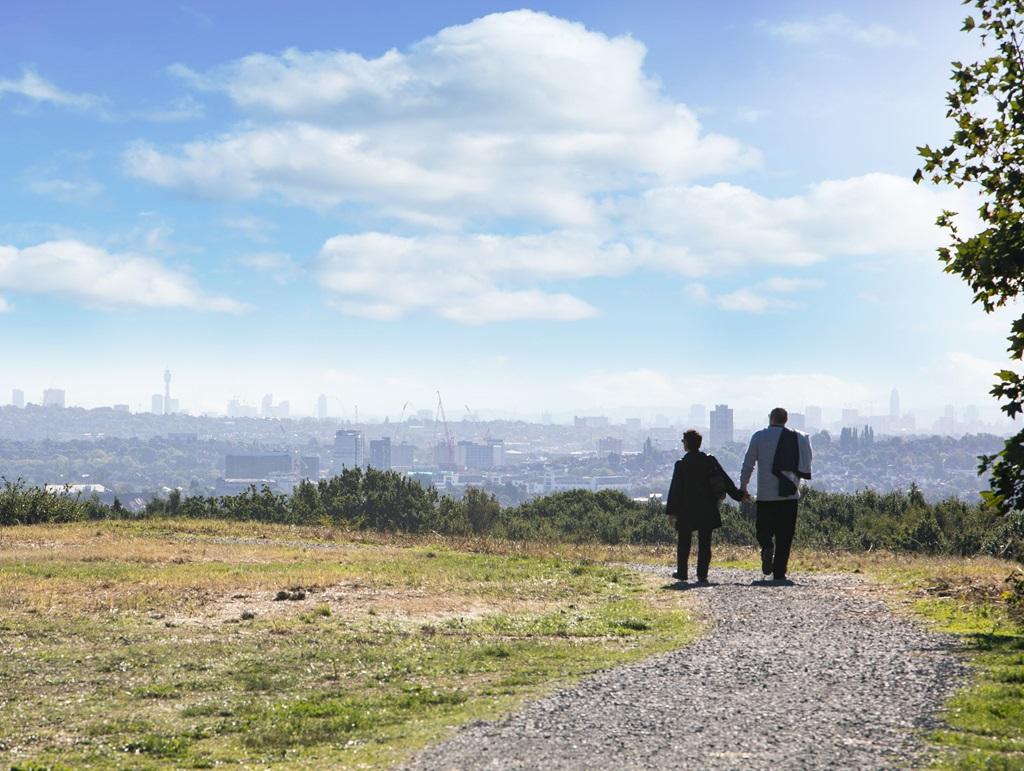 Two people walking down a path in Eastman Village, with the city in the background