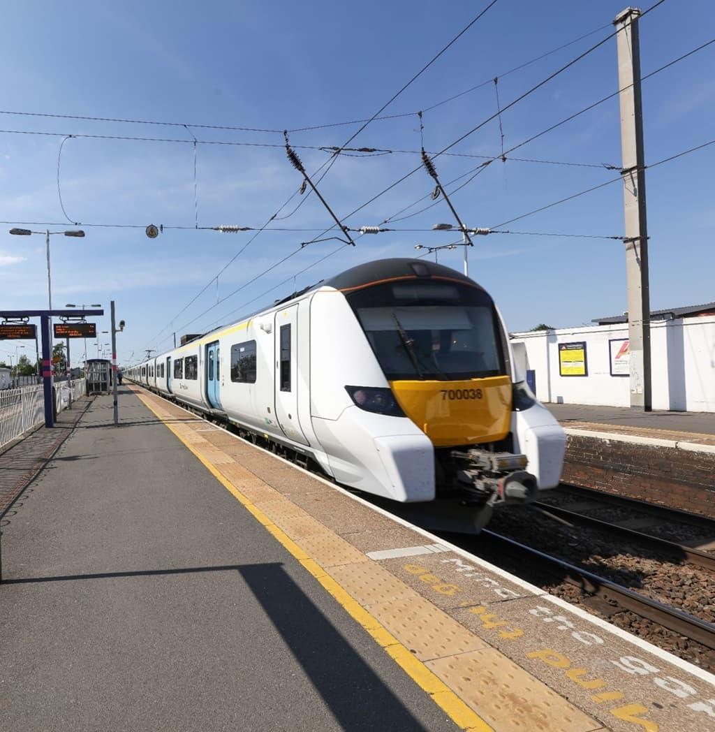 A yellow and white train on the tracks in London, Hendon Waterside Homes, NW9 7QA