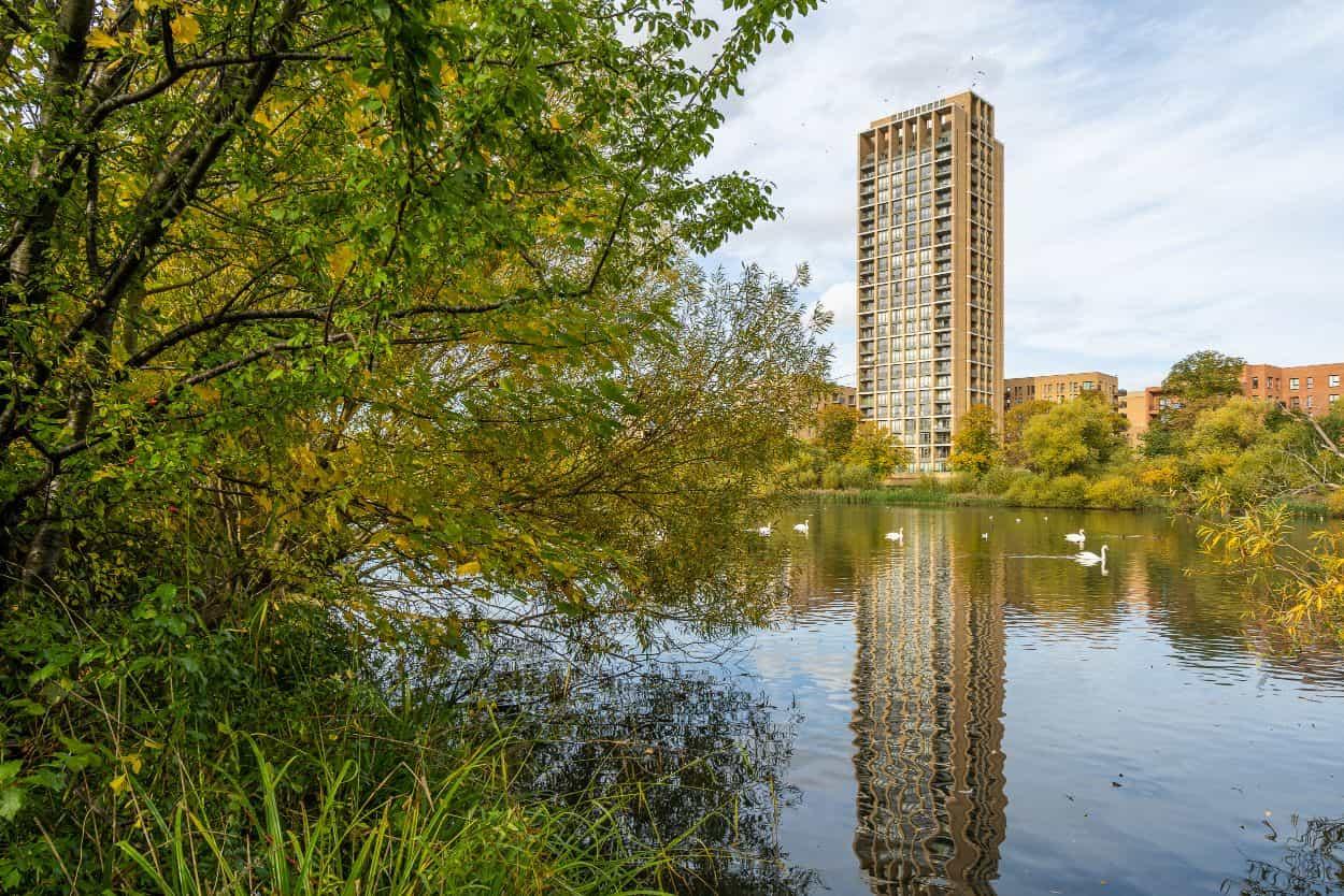 Hendon Waterside Homes, showcases a stunning reflection of a tall building in a nearby river